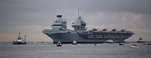 The HMS Queen Elizabeth aircraft carrier arriving in Port with tugboats