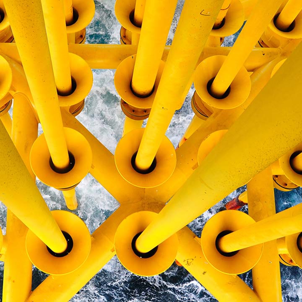 Yellow offshore rig with churning sea below