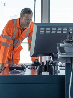 seafarer monitoring controls on a ship's bridge 