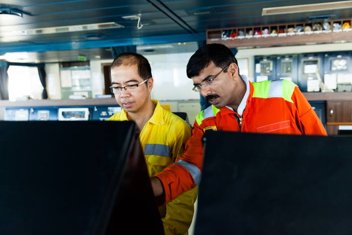 Surveyor instructing crew member on maintenance procedures