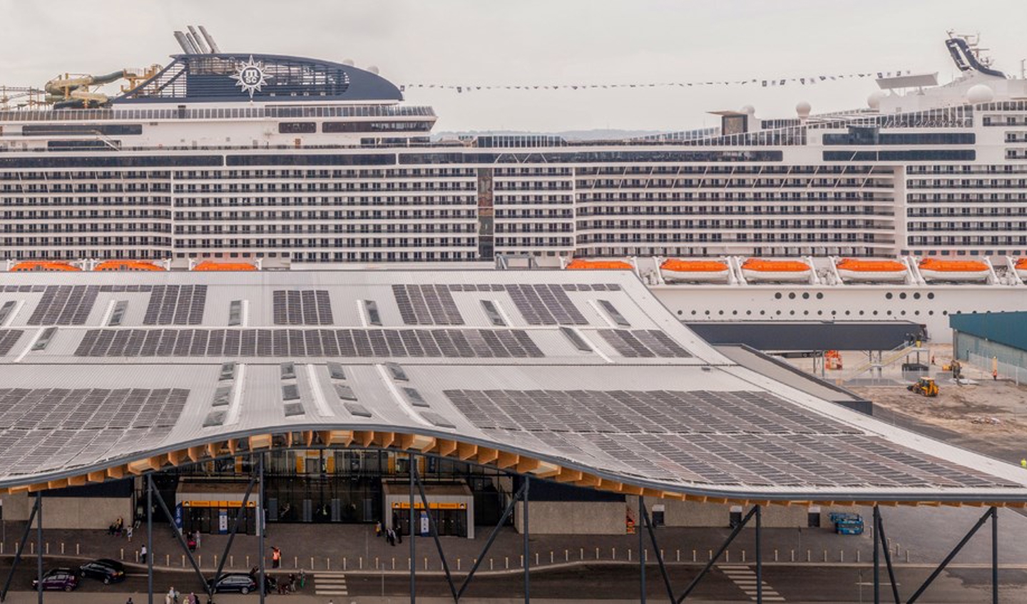 Large cruise ship docked at terminal. 