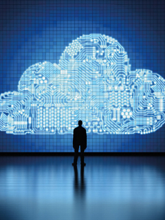 A man stands in front of a large digital cloud icon.