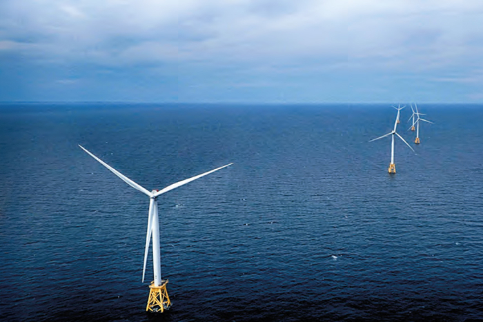 Offshore wind farm, rigged upon an open blue sea.
