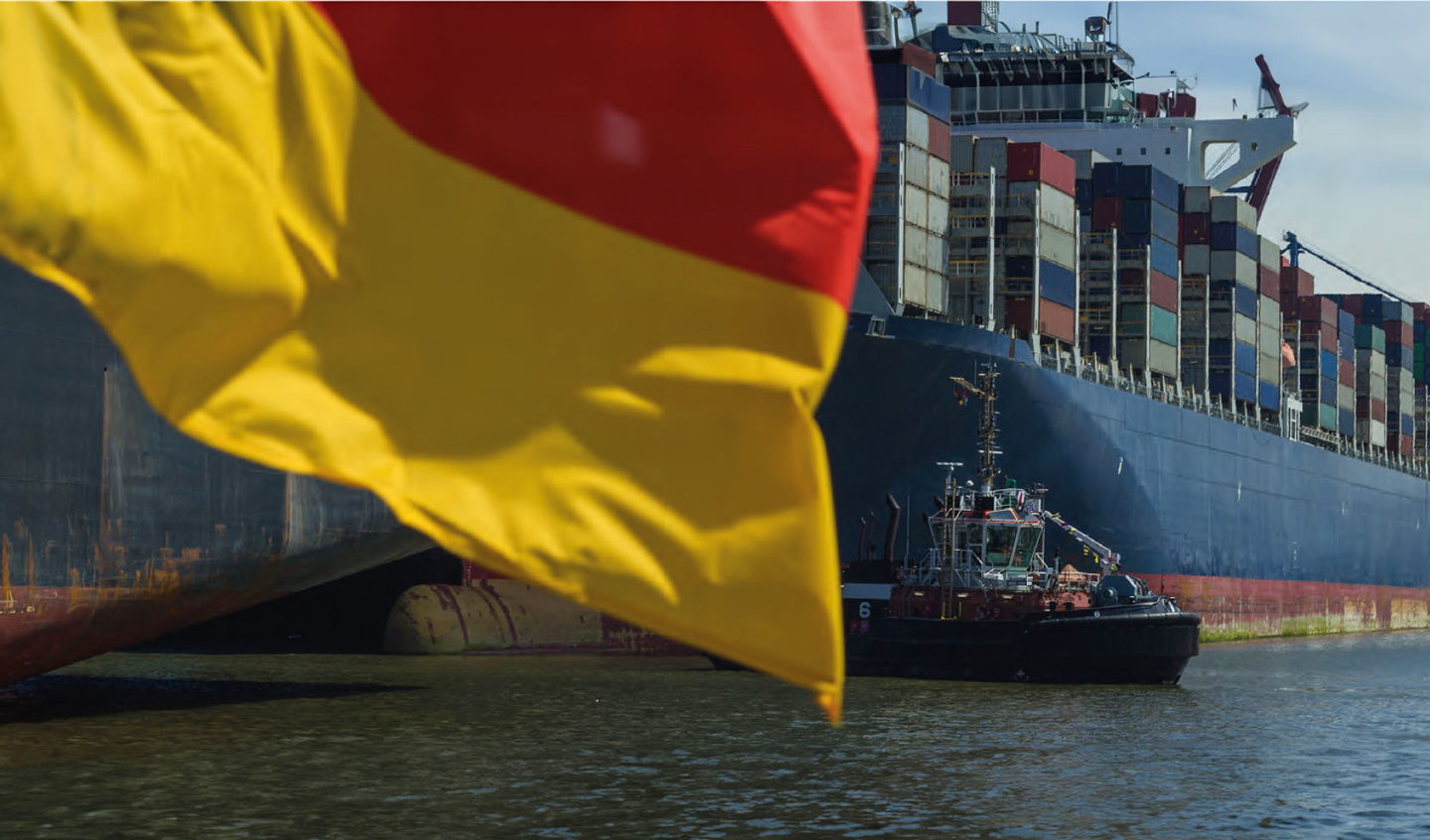 A german flag and a container ship in the background. 