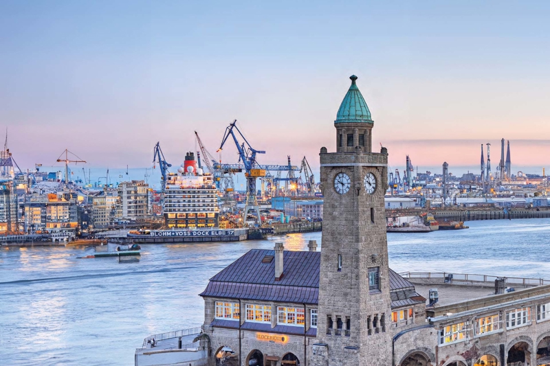 German harbour waters with construction and an old clock tower. 