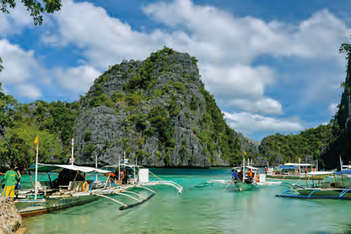 Tropical location in Philipines, boats meet at the shore.
