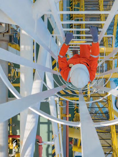Worker climbing an offshore rig ladder.