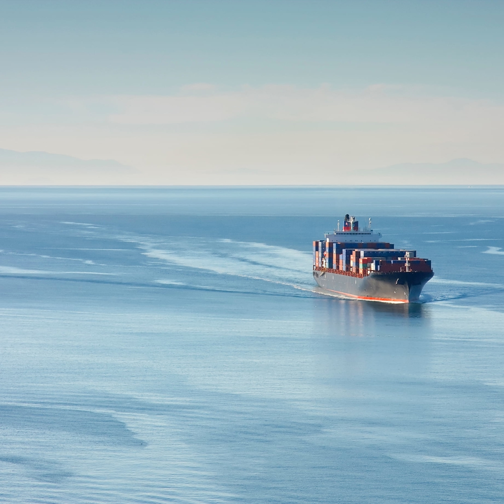 Large ship charges through sea.