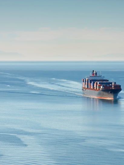 Large ship charges through sea.