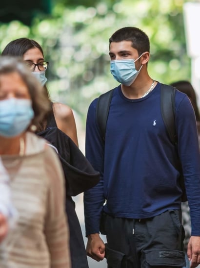 Person in mask in crowd.