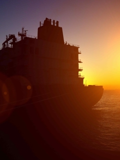 Offshore rig backlit by sunset.