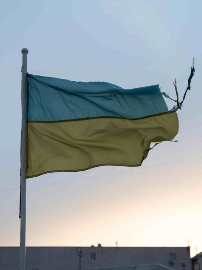 A torn flag flies in the wind.