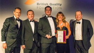 Global Energy Transformation team (four men and a woman) holding a paper certificate (2014 British Quality Foundation’s Award)