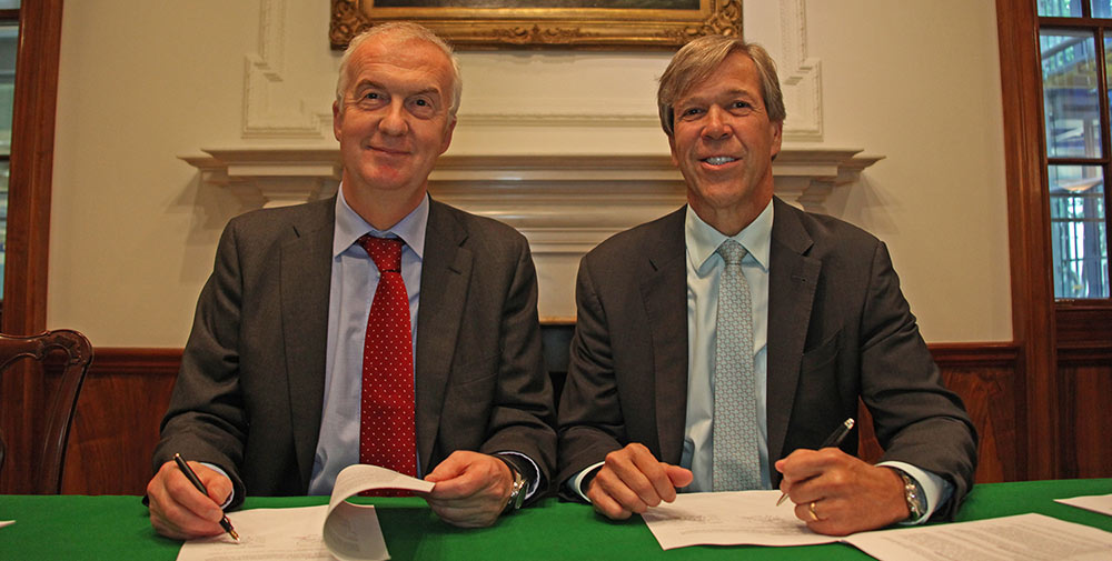 Tom Boardley and Brien Bolsinger sitting side by side at a table, signing the Memorandum of Understanding documents.