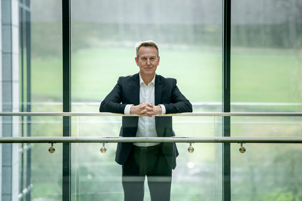 Lloy'd's Register's David Clark standing in office space leaning on barrier