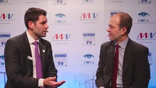 Front view of Arve Sandve being interviewed by EWA, both men are sitting in front of backdrop with multiple logos.
