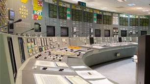 Image of a large operations room with curved work station, multiple wall screens and technology.