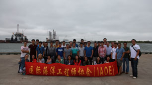 Group of participants taking part in the field trip for Young Professionals, standing on a wharf with sign in front of them.