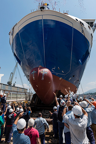 LNG-fuelled LR Classed ferry, tied down to the platform, being launched at shipyard, with crowd surrounding it taking photos.