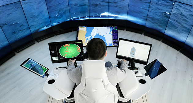 Top view of crew member in front of controls and computer screens during demonstration