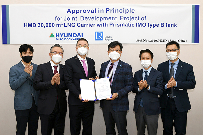 Group photo of representatives when LR awards AiP to HMD, standing in front of signage.