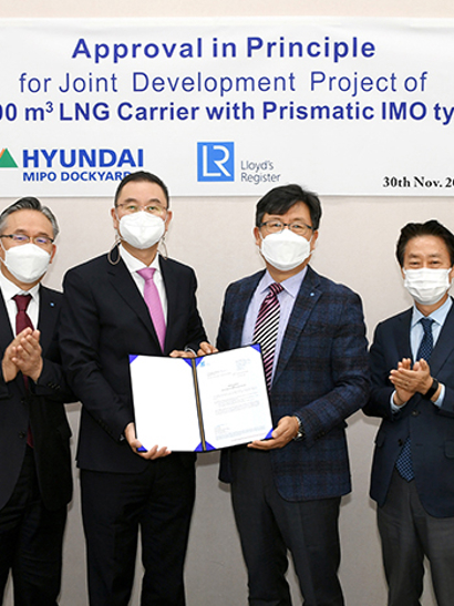 Group photo of representatives when LR awards AiP to HMD, standing in front of signage.