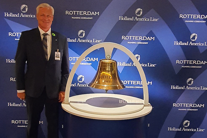 Piet Mast, LR Key Account Development Director, standing next to the bell at the naming ceremony, in front of event signage.