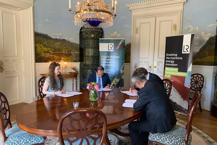Four representatives from LR, HD KSOE, HHI and Knutsen, seated at a table signing the JDP documents.