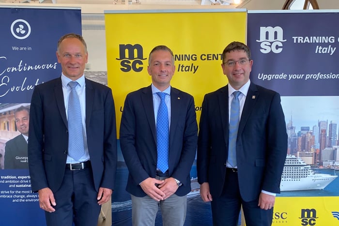 Group of members from MAN ES, MSC and LR in front of MSC signage banners.