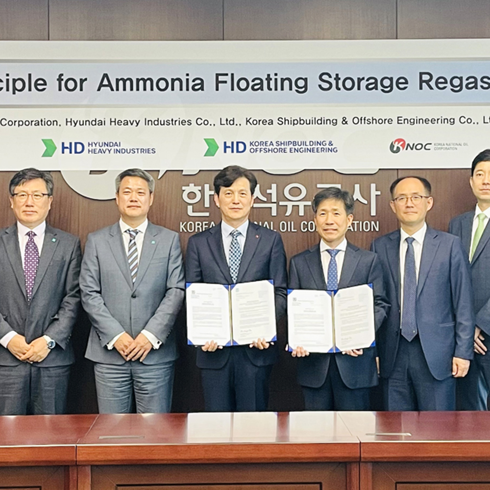 Group photo in board room in front of signage for acceptance of the awarded Approval in Principle.