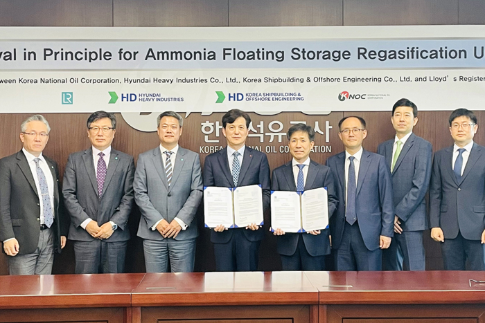 Group photo in board room in front of signage for acceptance of the awarded Approval in Principle.