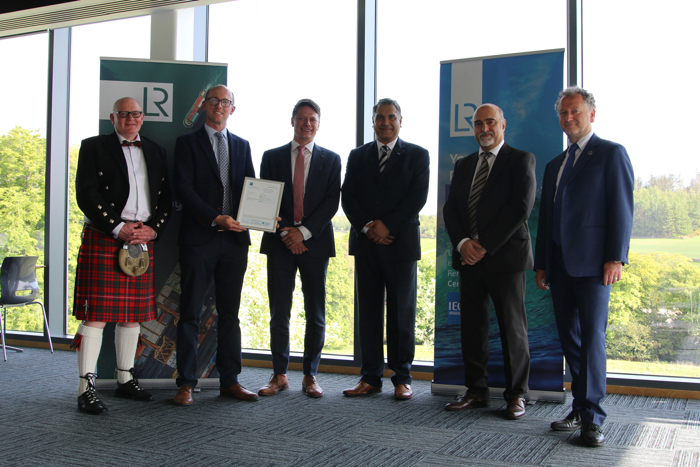 Group photo of members and recipient who was awarded the Feasibility Statement by LR, in front of LR signage banners.
