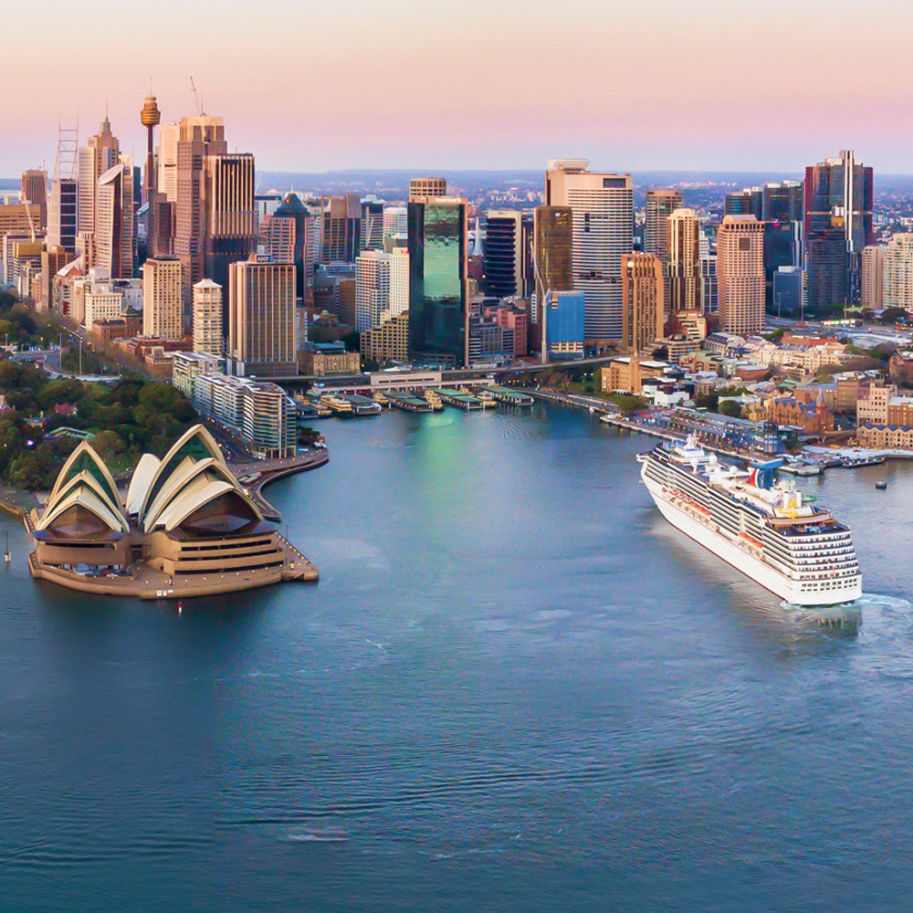 Image of Sydney Harbour from the sky.  Sydney Opera House is on the left and a ship is coming into port on the right.