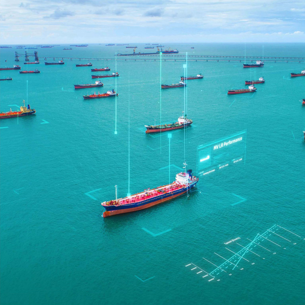 Birds eye view of ships anchored in calm seas. A digital overlay implies the central ship is selected in a user interface, and has the Ship name of MV LR Performance.