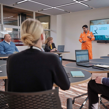 Surveyor giving a presentation in front of a class in high visibility outfit