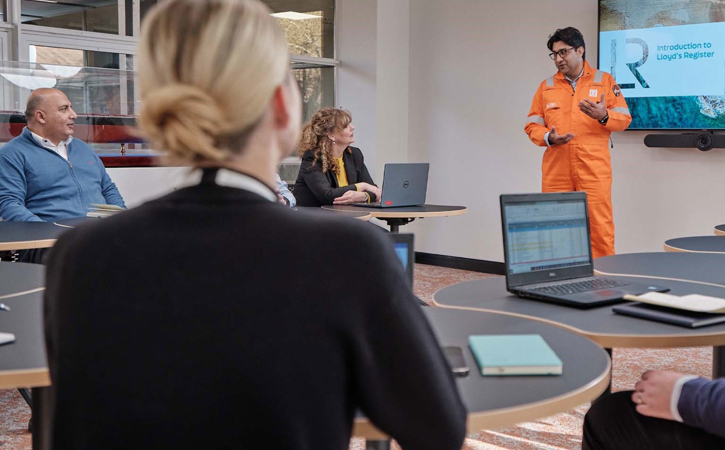 Surveyor giving a presentation in front of a class in high visibility outfit