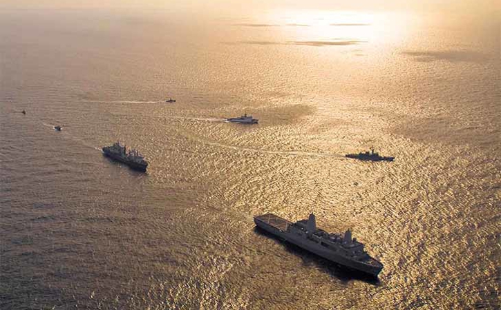 Naval ships out at sea at sunset