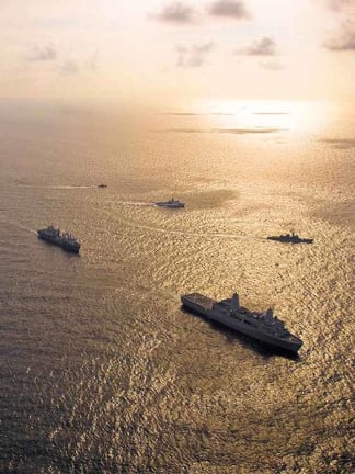 Naval ships out at sea at sunset