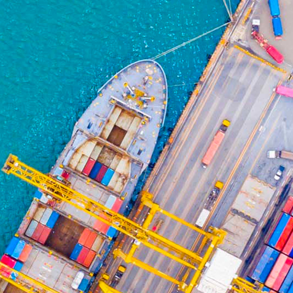 Overhead image of cargo ship with yellow crane at port