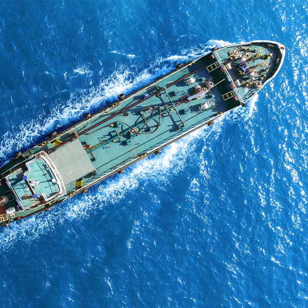 Ship from above charging through blue sea