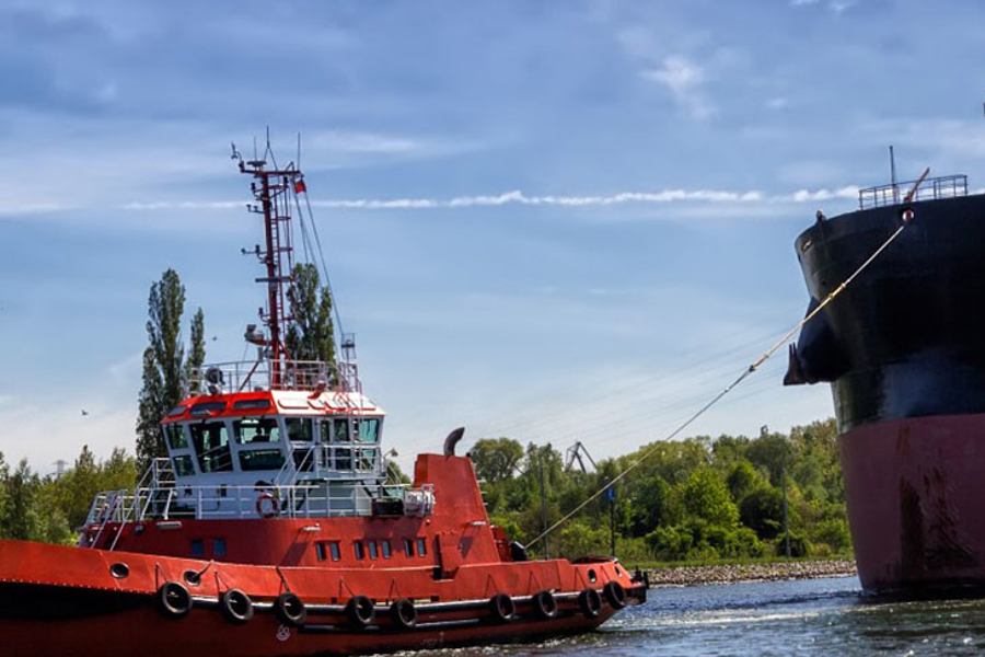 A barge pulls along a tug boat.