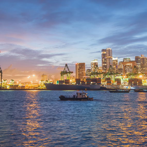 Singapore harbour at night, small boats and container ships. 