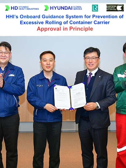 Group photo of LR and HHI representatives clapping hands and two members holding framed Approval in Principle document.