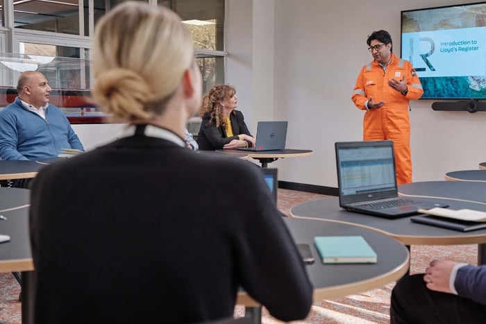 Surveyor giving a presentation in front of a class in high visibility outfit